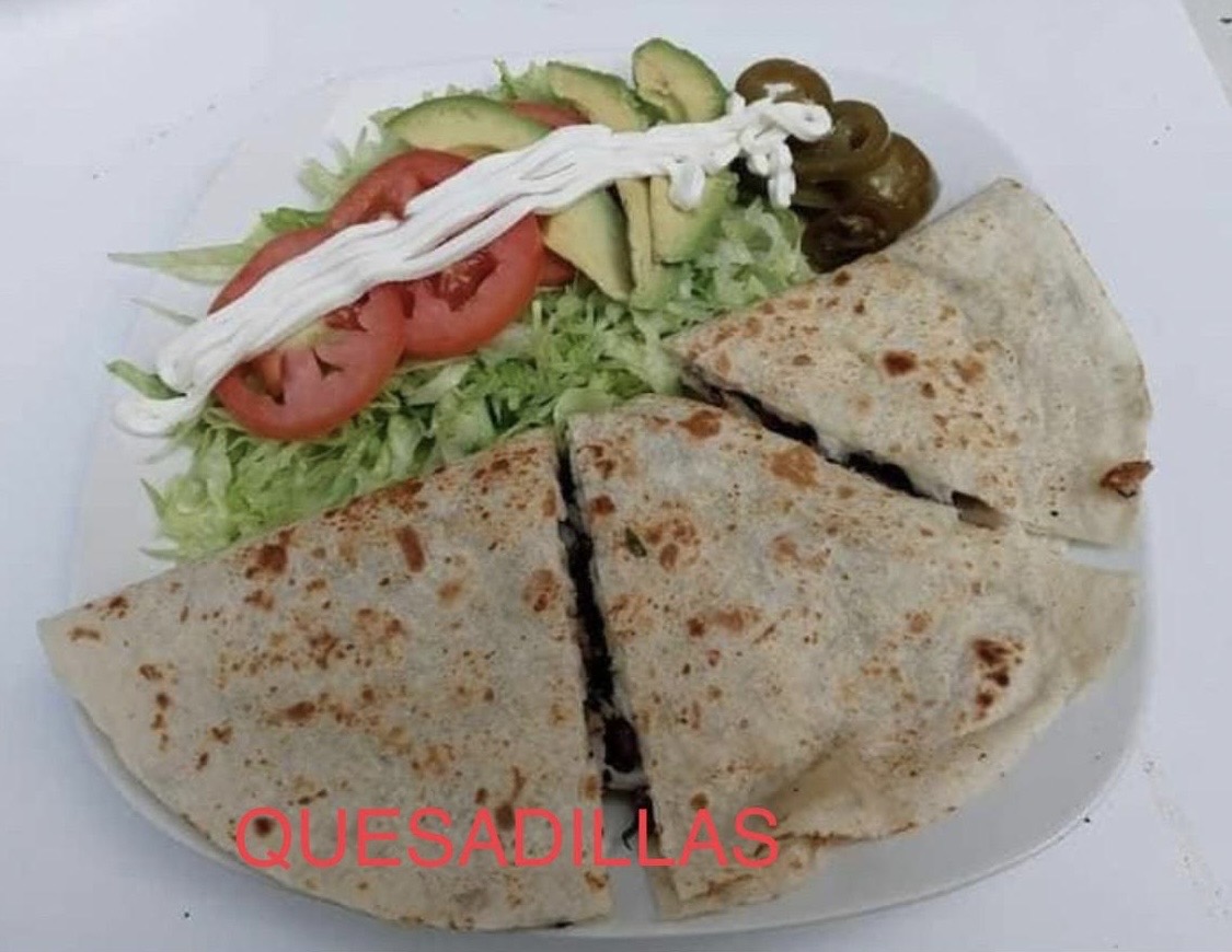 Three tacos with radish, cilantro and lime on foil